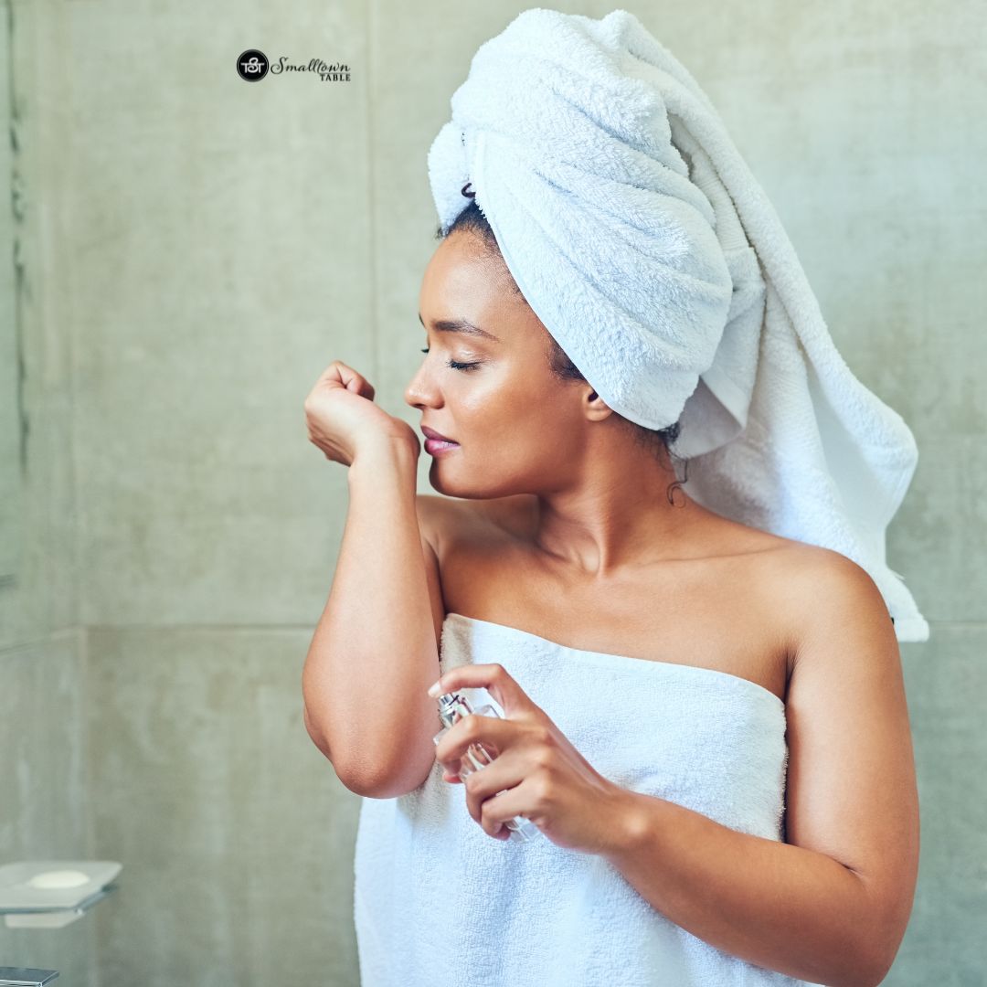 girl smelling perfumed her wrist after shower wrapped in a towel and a head wrap