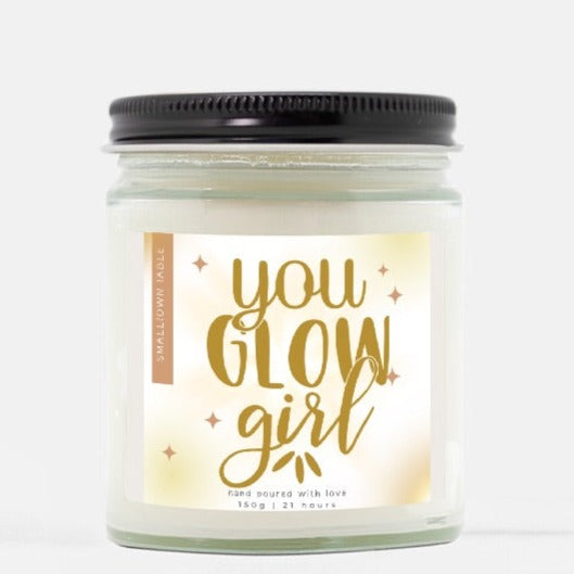 glass jar candle with label in gold that sys You GLow Girl